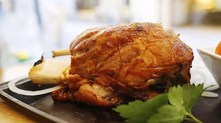 Roasted meat served with fresh herbs