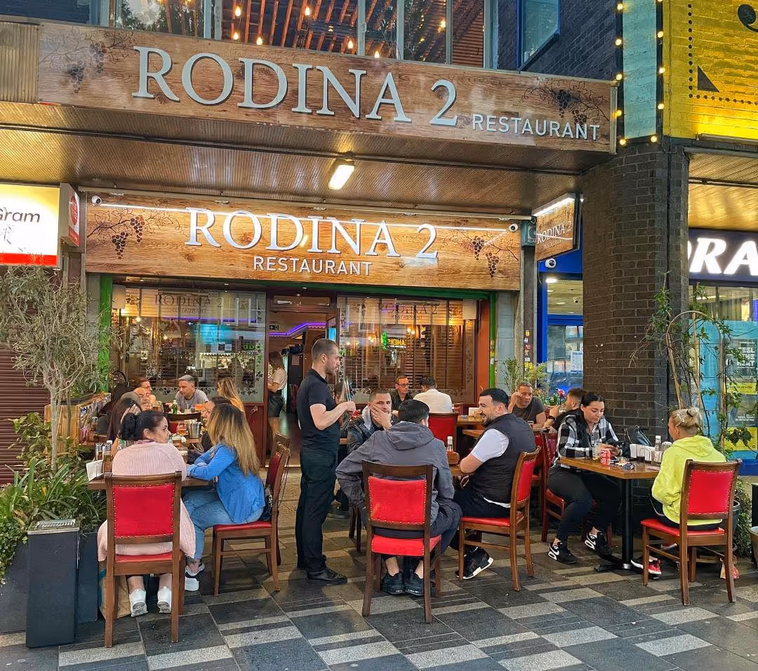 Rodina 2’s front terrace and sign, full of guests